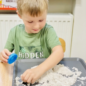 Dzieci bawią się piaskiem kinetycznym.