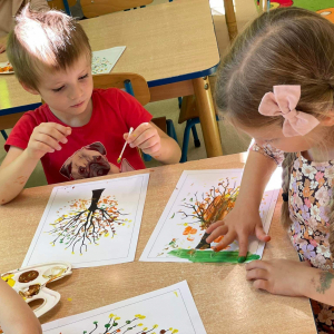Dzieci malują farbami jesienne drzewa