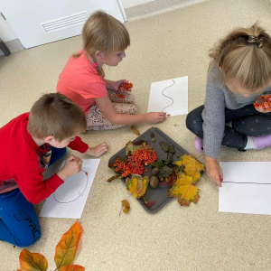 Dzieci układają kompozycje z kolorowych liści