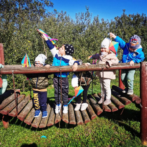 Dzieci stoją na mostku na placu zabaw