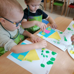 Dzieci wyklejają domki z kolorowego papieru
