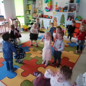 Dzieci tańczą na dywanie w rytm muzyki