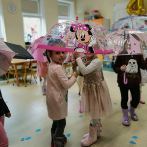 Dziewczynki stoją pod parasolem