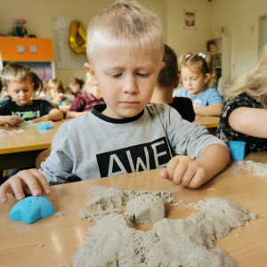 Chłopiec bawi się piaskiem kinetycznym 