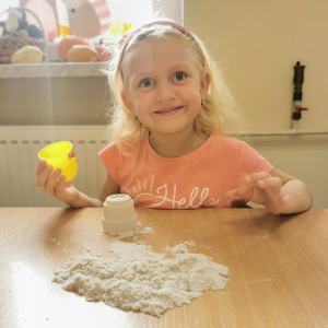 Dziewczynka bawi się piaskiem kinetycznym 