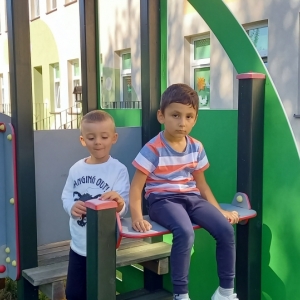 Dzieci z grupy Motylki bawią się na placu zabaw przy przedszkolu