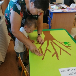 Zdjęcie przedstawia dzieci z grupy Żabki podczas tworzenia "Drzewka dłoni" 