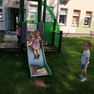 Na zdjęciu dzieci z grupy Żabki bawią się na placu zabaw przy przedszkolu