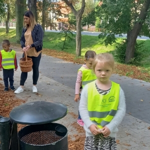 Na zdjęciu dzieci z grupy Motylki podczas spaceru w parku zbierają kasztany