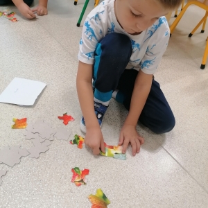Na zdjęciu dzieci z grupy Sówki podczas układania jesiennych puzzli