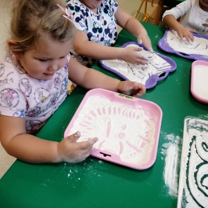 Na zdjęciu dzieci z grupy Żabki podczas zabaw manualnych mąką
