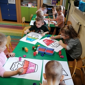 Na zdjęciu dzieci z grupy Żabki malują farbami lampę