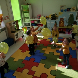 Na zdjęciu dzieci z grupy Biedronki, które bawią się w sali przedszkolnej i grają balonikiem, podbijają balon do góry