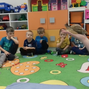 Na zdjęciu dzieci z grupy Jezyki słuchają, jak Pan opowiada o ślimaku afrykańskim
