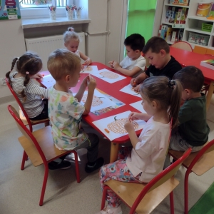 Dzieci rysują przy stoliku w sali 