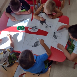 Dzieci rysują przy stoliku w sali 