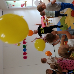 Dzieci bawą się kolorowymi balonami.