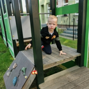 Na zdjęciu chłopiec bawi się na placu zabaw.