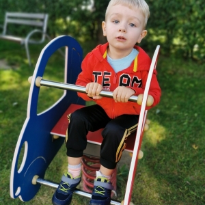 Na zdjęciu chłopiec bawi się na placu zabaw. Buja sę na bujaku.