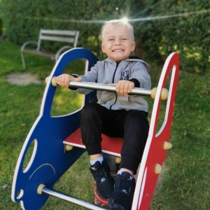 Na zdjęciu chłopiec bawi się na placu zabaw.