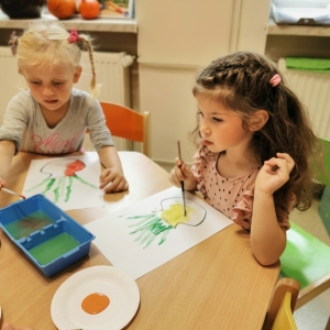 Dzieci malują farbami pracę plastyczną.